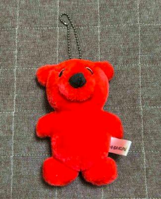 Red Chiba-kun plush keychain with a ball chain on a gray fabric background.