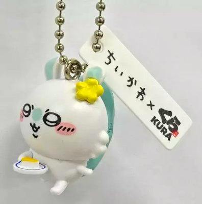 Plastic keychain of the Momonga character from ちいかわ × くら寿司 collaboration, shown on a ball chain with a white rectangular tag and small plate accessory.