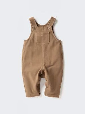 Brown cotton children's salopette (overalls) with a front pocket and shoulder straps laid flat on a white background.