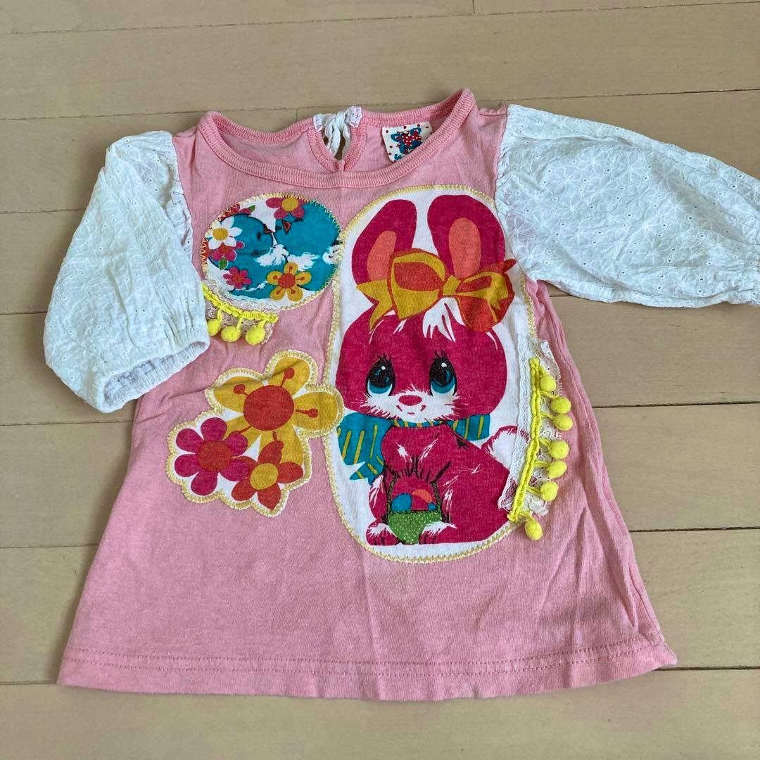 Pink children's cotton T‑shirt with white lace puff sleeves and a large bunny-and-flower print, shown laid flat.