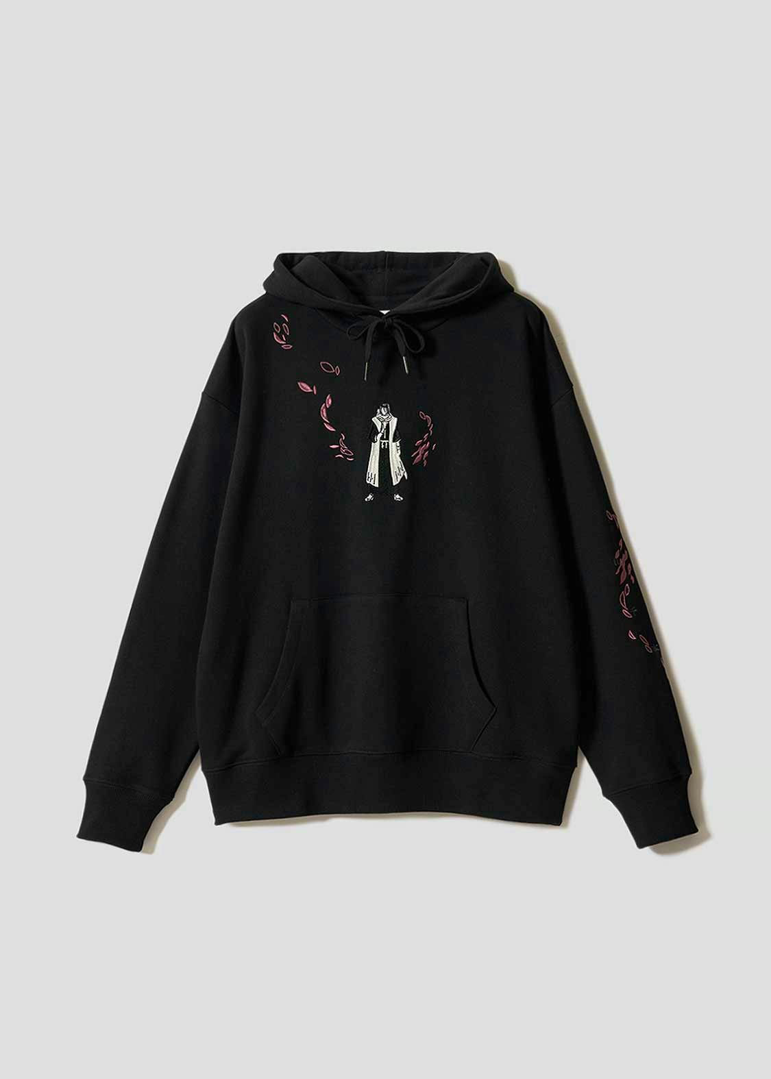 Black big-silhouette hoodie laid flat showing a hood, kangaroo pocket, and a central printed character graphic with pink petal motifs.