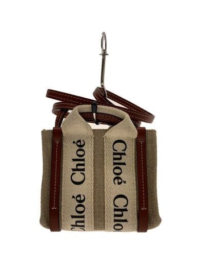 Front view of a Chloe canvas shoulder bag in brown with branded canvas straps and leather trim hanging on a hook.