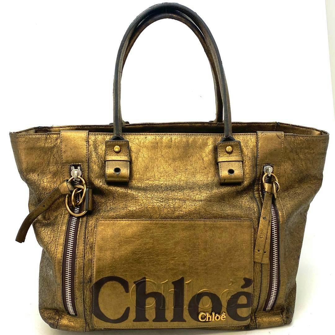 Front view of the brown leather Chloé tote bag showing dual top handles, a front pocket with the Chloé logo and two vertical zip details.