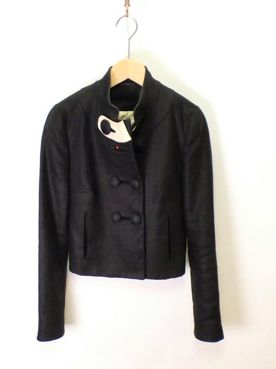 Black Chloe silk shantung jacket with oversized buttons hanging on a hanger.