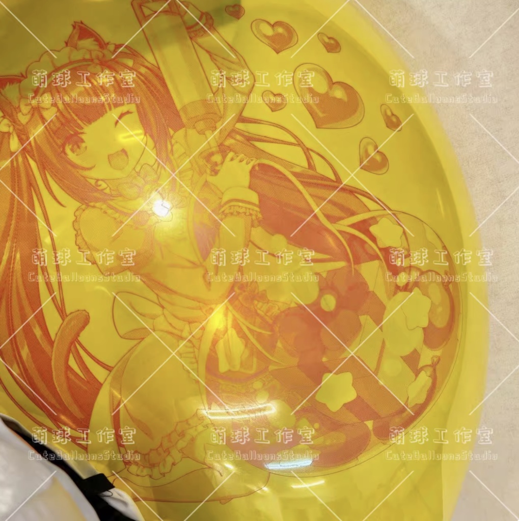 Yellow inflated balloon with a brown-ink printed anime-style character illustration.