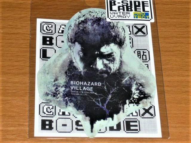 Paper sticker for Biohazard Village showing a distressed portrait and tree-like graphic on a backing card with a B-SIDE LABEL logo.