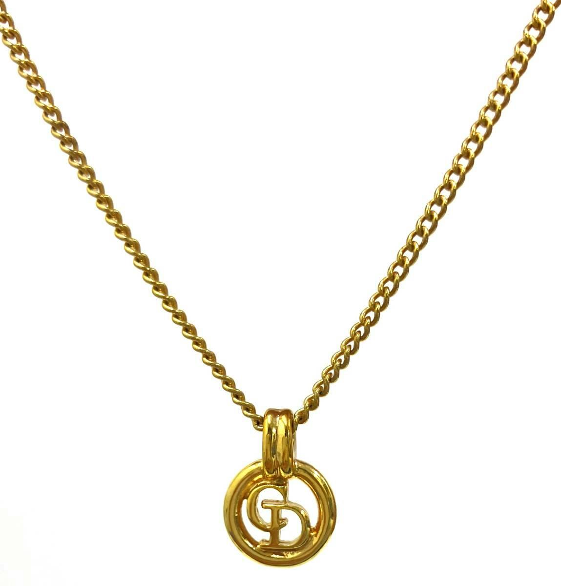 Gold-tone necklace with a circular CD logo pendant on a chain against a white background.