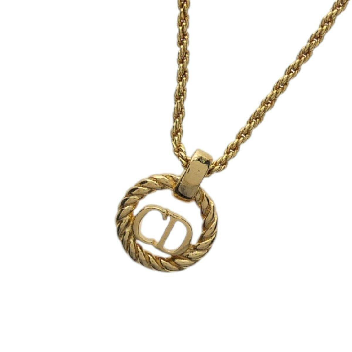 Gold-color necklace showing a rope-style chain and a twisted circular pendant with a CD logo.