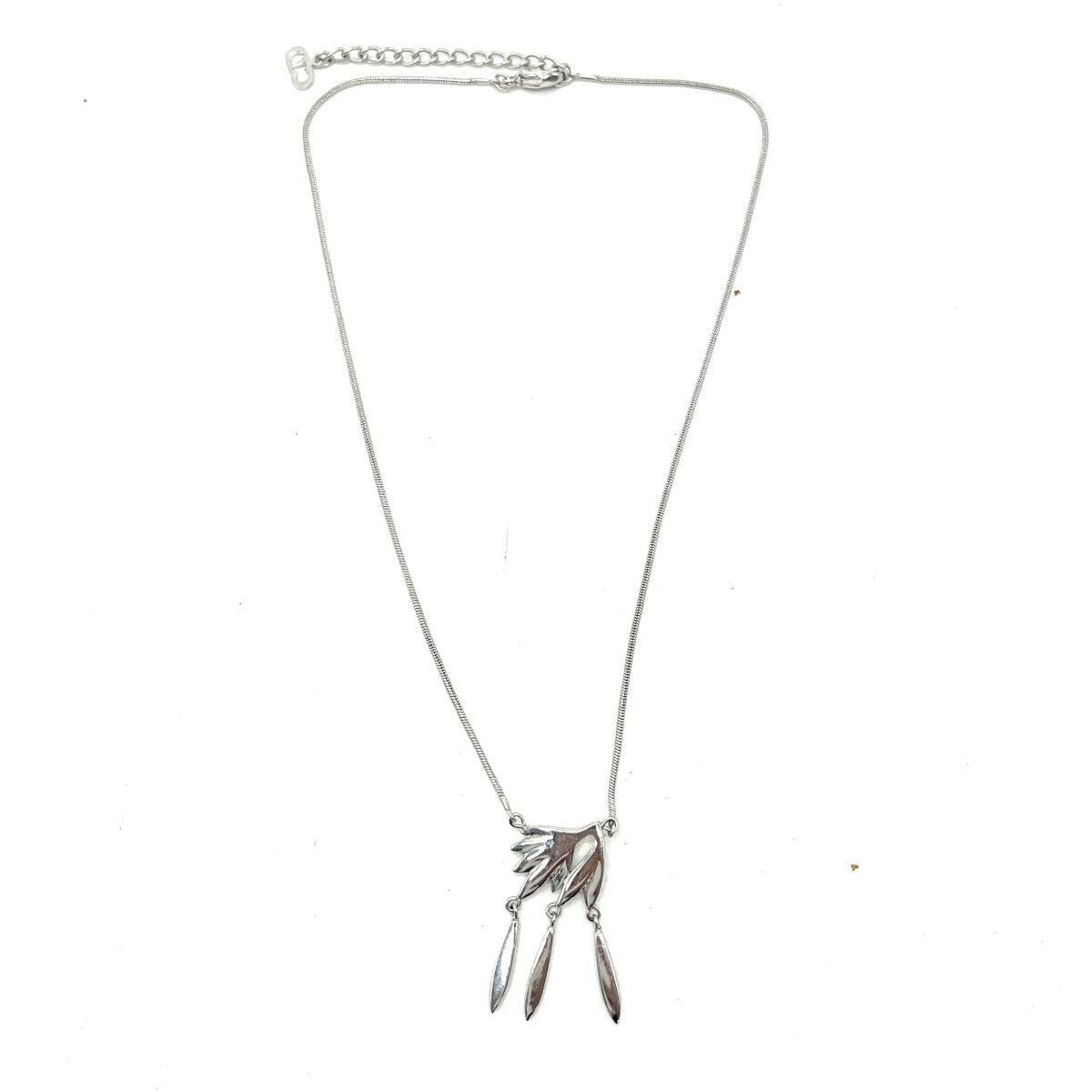 Silver Christian Dior necklace with a feather-style pendant and three dangling leaf-shaped charms on a thin chain against a white background.