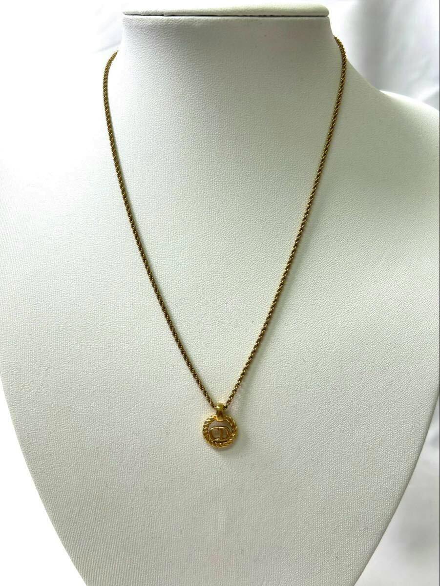 Christian Dior gold CD-logo necklace displayed on a white necklace bust.