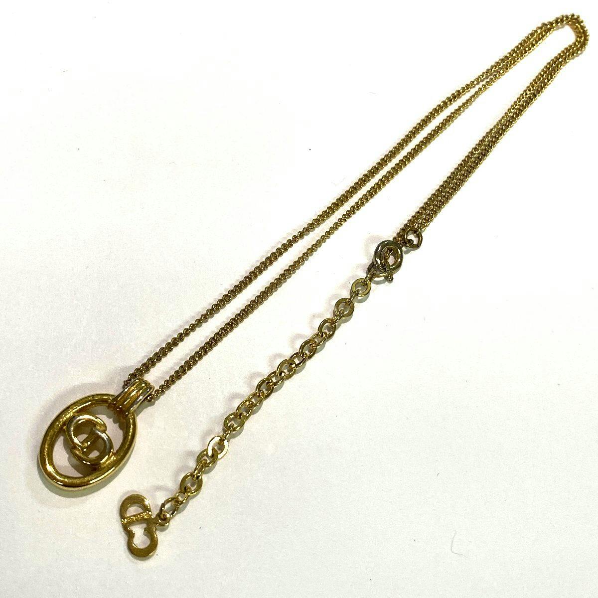 Gold-tone Christian Dior necklace with a CD logo pendant and chain laid out on a white background.