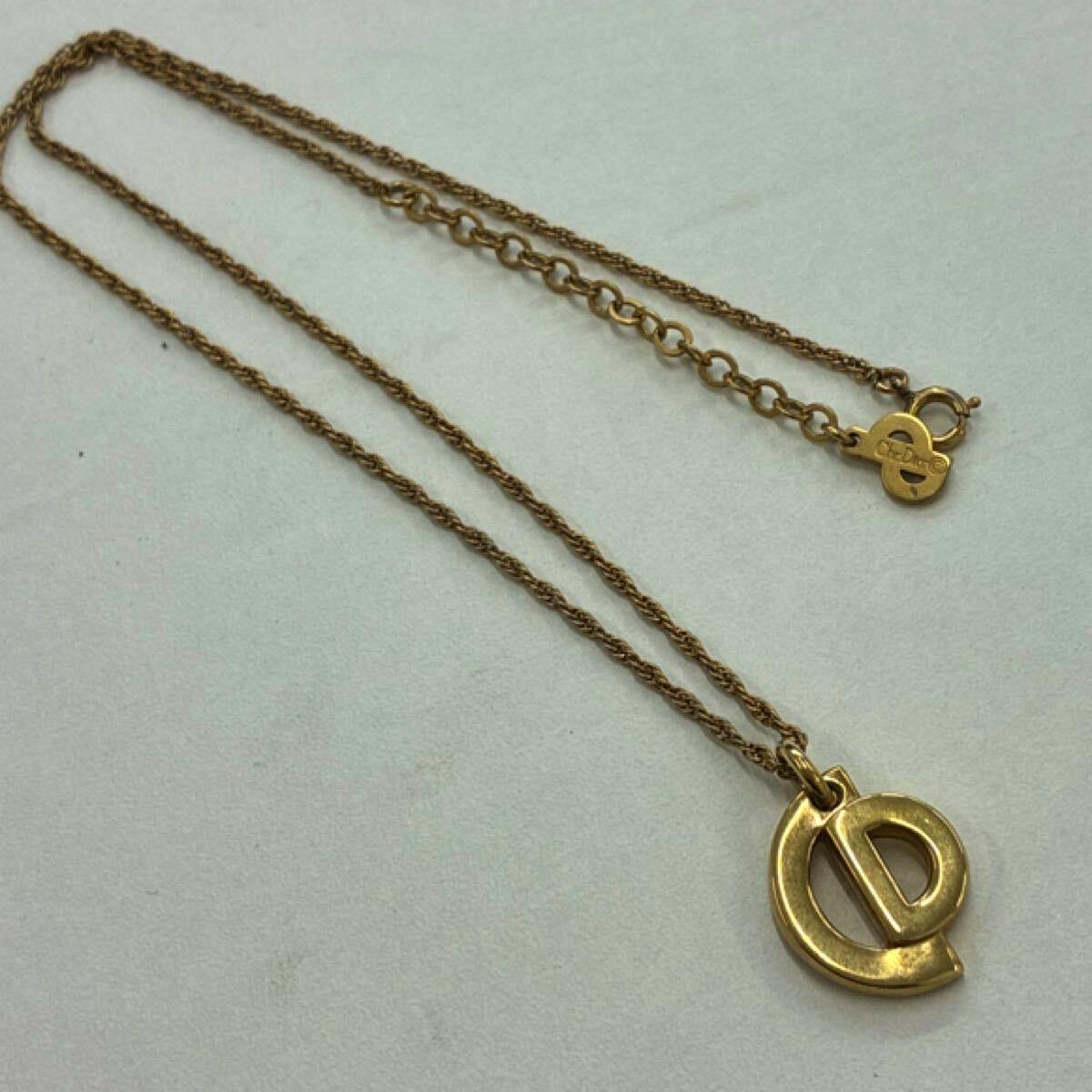 Gold-colored Christian Dior CD logo necklace laid flat showing the pendant, chain, and clasp.