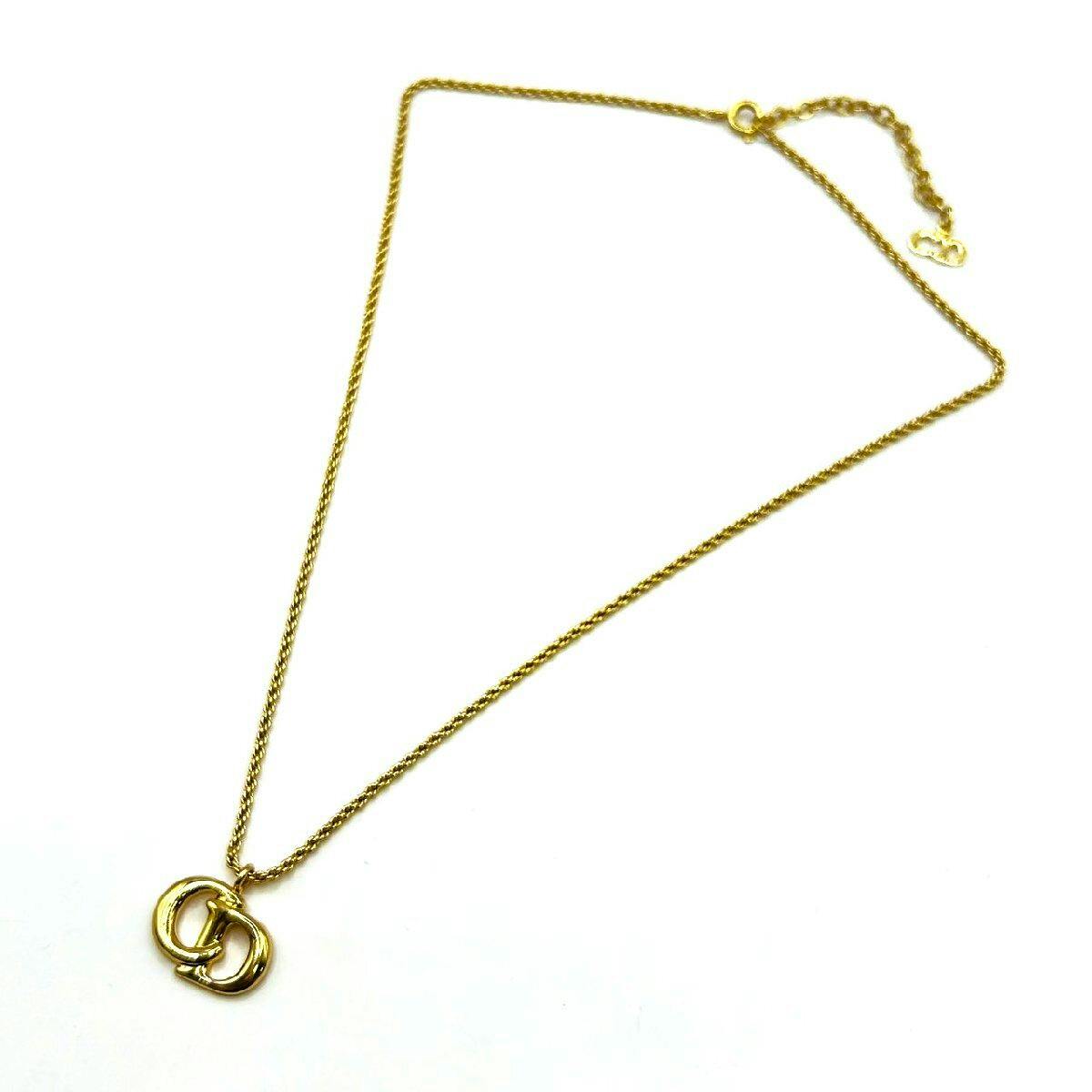 Gold-tone Christian Dior CD logo necklace laid flat on a white background showing the pendant and chain.