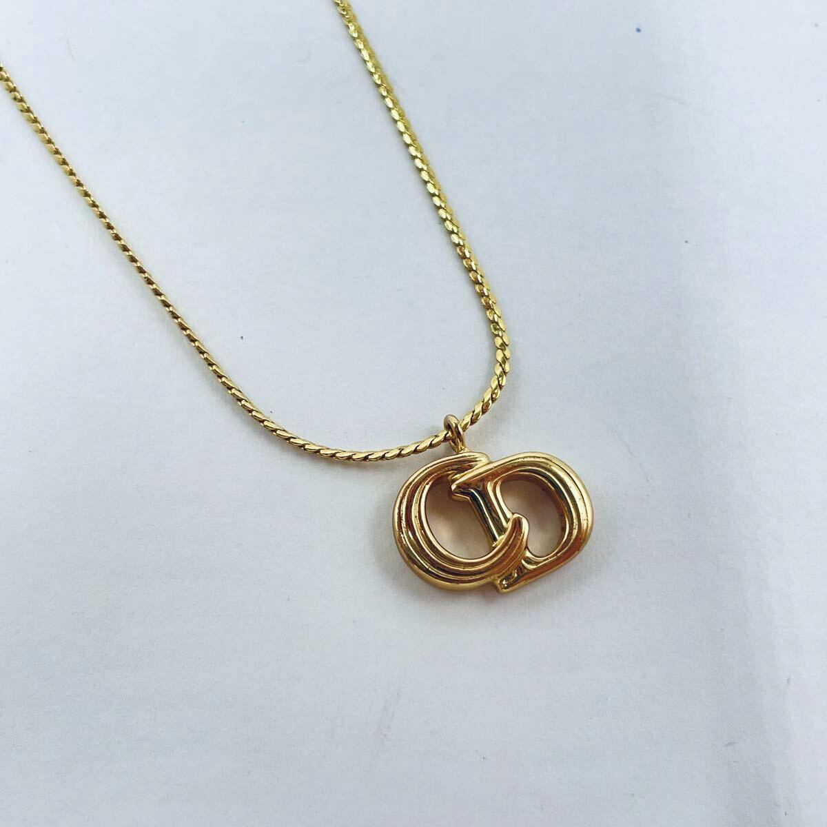 Gold-tone Christian Dior necklace with a CD logo pendant on a gold chain against a white background.