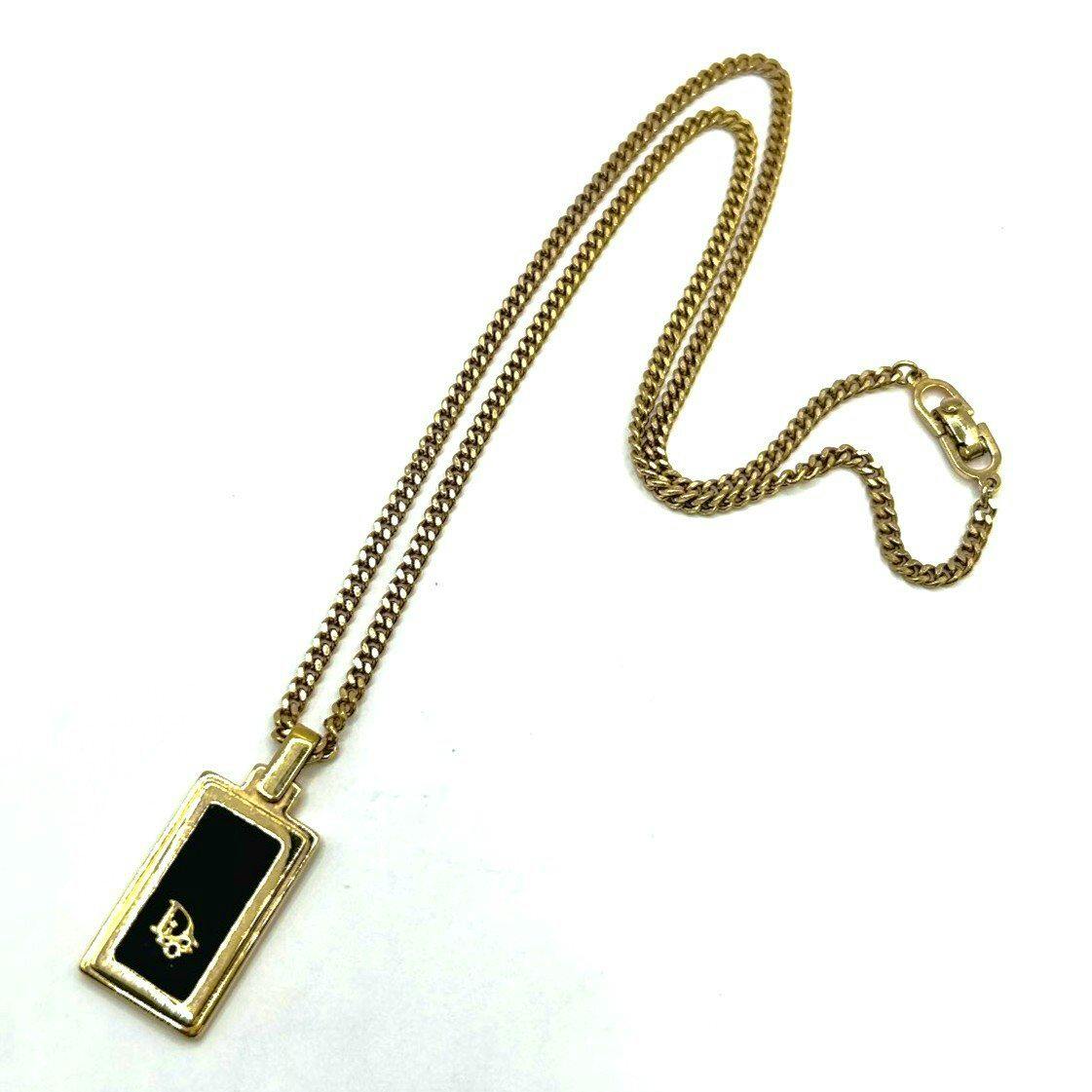 Christian Dior gold-tone curb chain necklace with a rectangular black-centred pendant bearing a CD logo, shown on a white background.