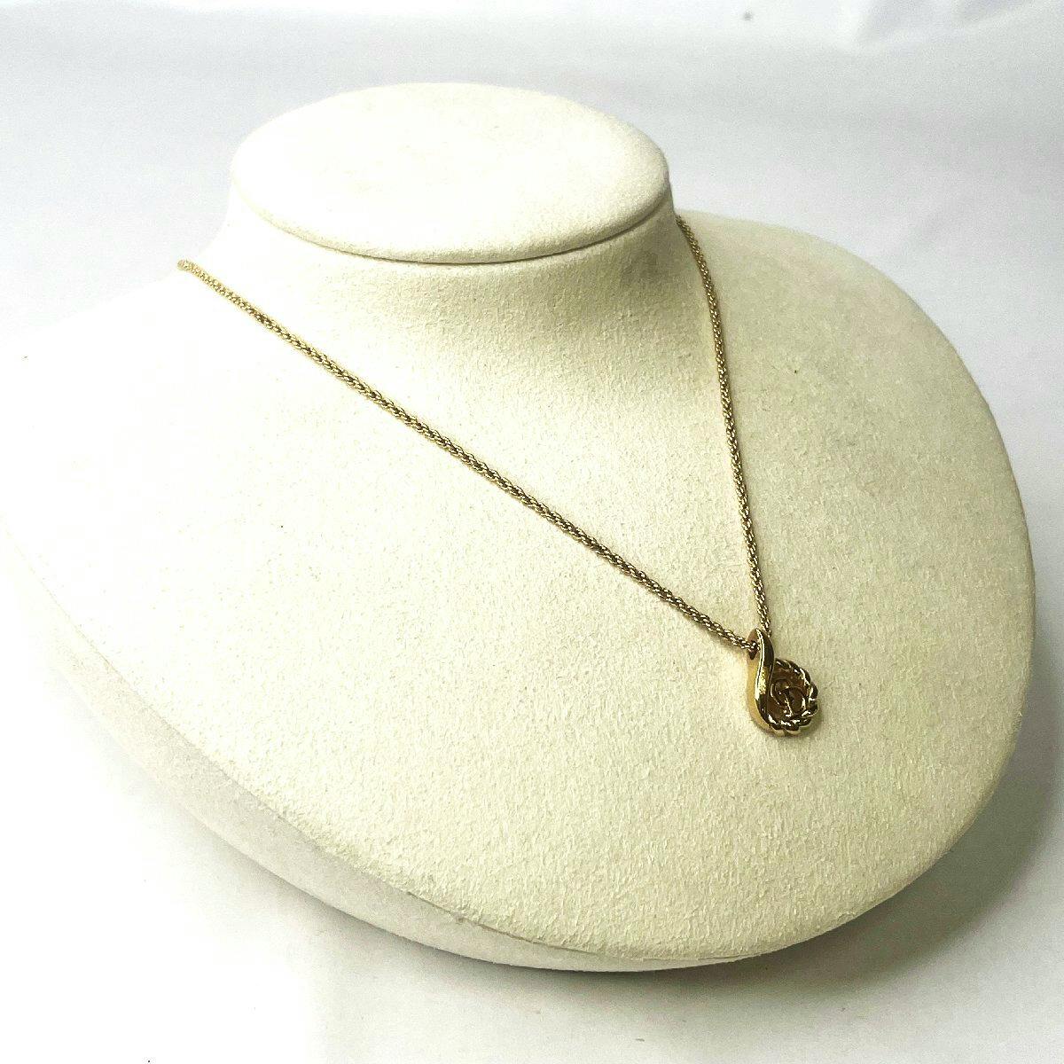 Gold-colored Christian Dior teardrop CD-logo twist pendant necklace displayed on a beige necklace bust.