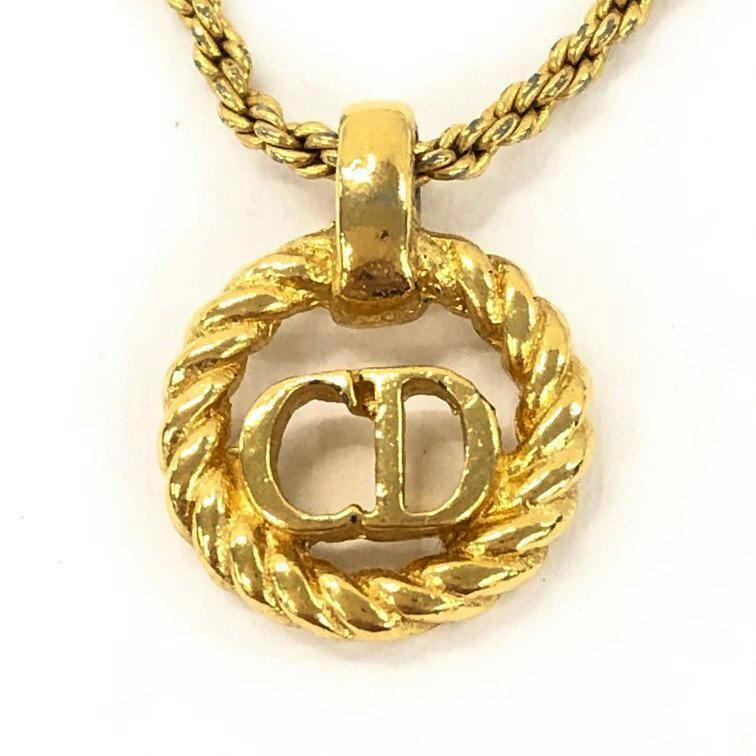 Close-up of a gold-tone Christian Dior CD logo twisted circle pendant on a rope-style chain.