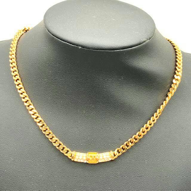 Gold-tone Christian Dior chain necklace with line-stone embellished center clasp displayed on a black necklace bust.