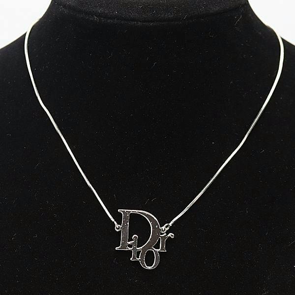 Silver-color Dior logo pendant necklace displayed on a black necklace bust.