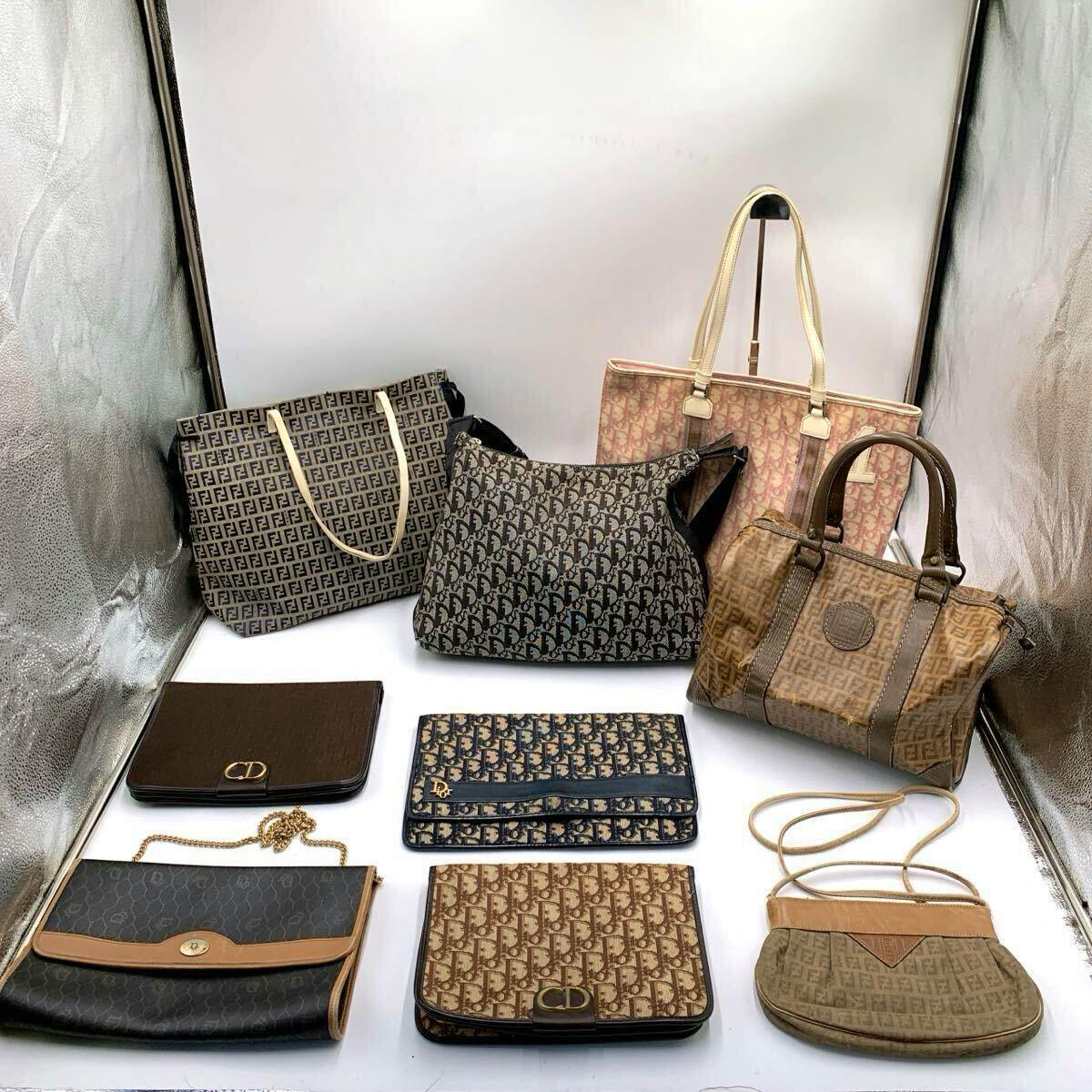 Nine bags and small purses with Christian Dior and Fendi monogram patterns arranged on a white background.