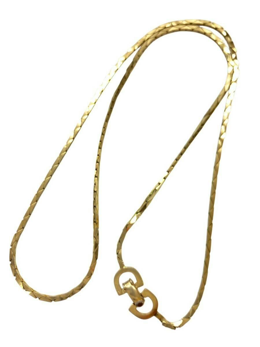 Gold-colored flat chain necklace with geometric cut pattern and a clasp photographed on a white background.
