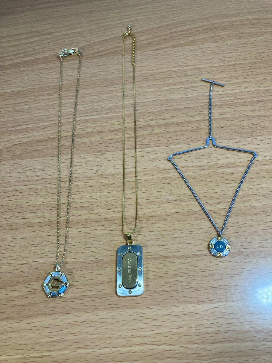 Three necklaces from the branded set laid flat on a wooden surface.