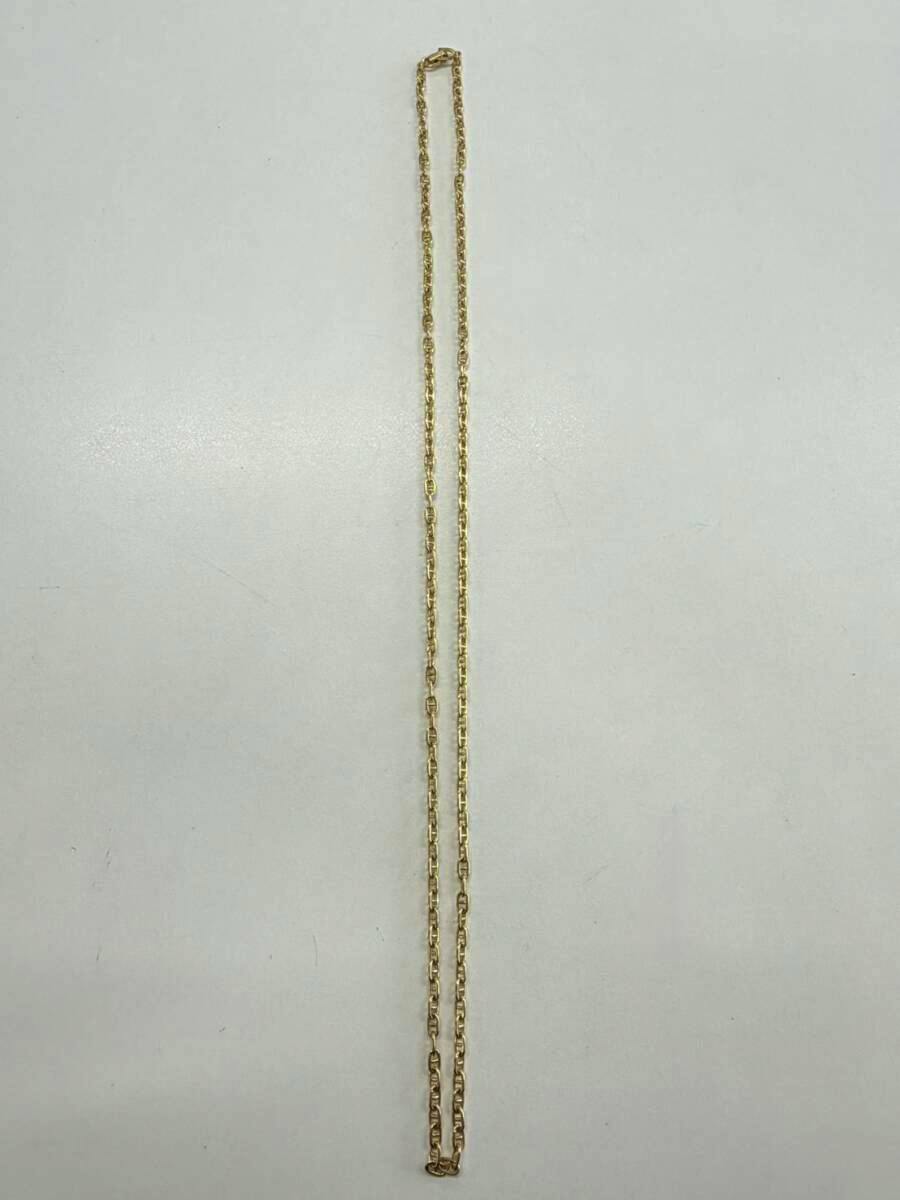 Christian Dior gold necklace chain laid flat on a white background.