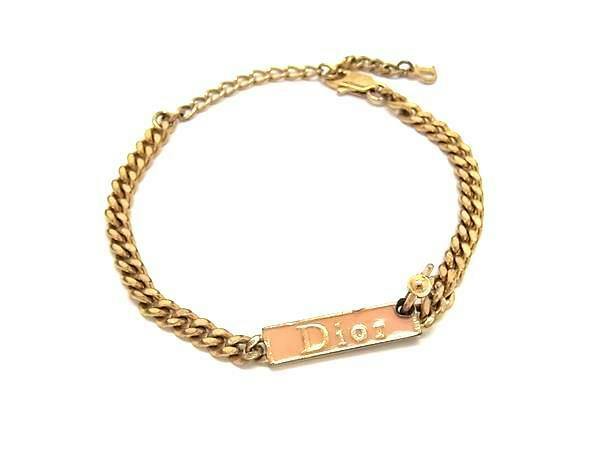 Gold-tone Christian Dior chain bracelet with a rectangular "Dior" nameplate and adjustable clasp on a white background.