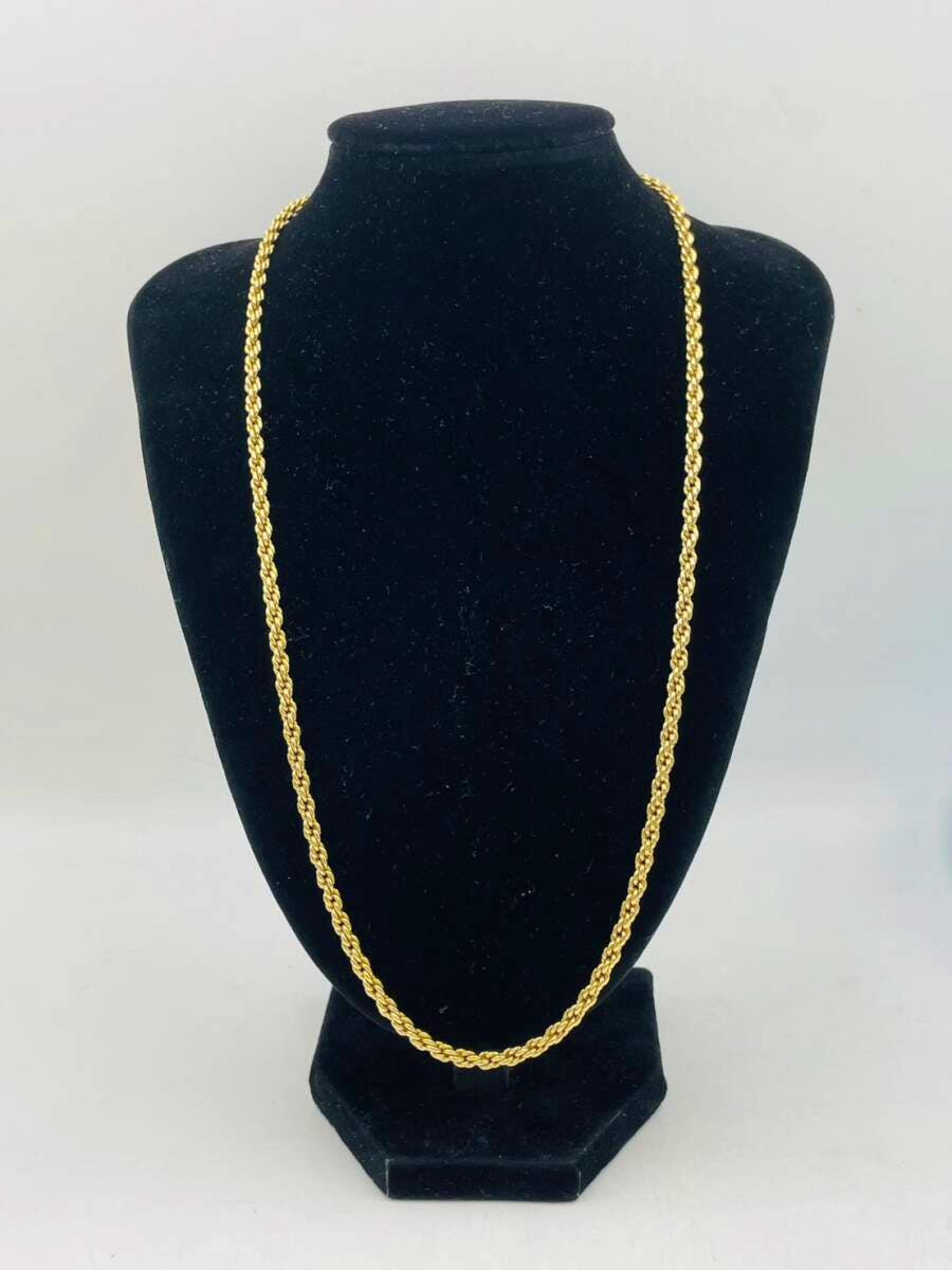 Christian Dior gold-color chain necklace displayed on a black necklace bust.