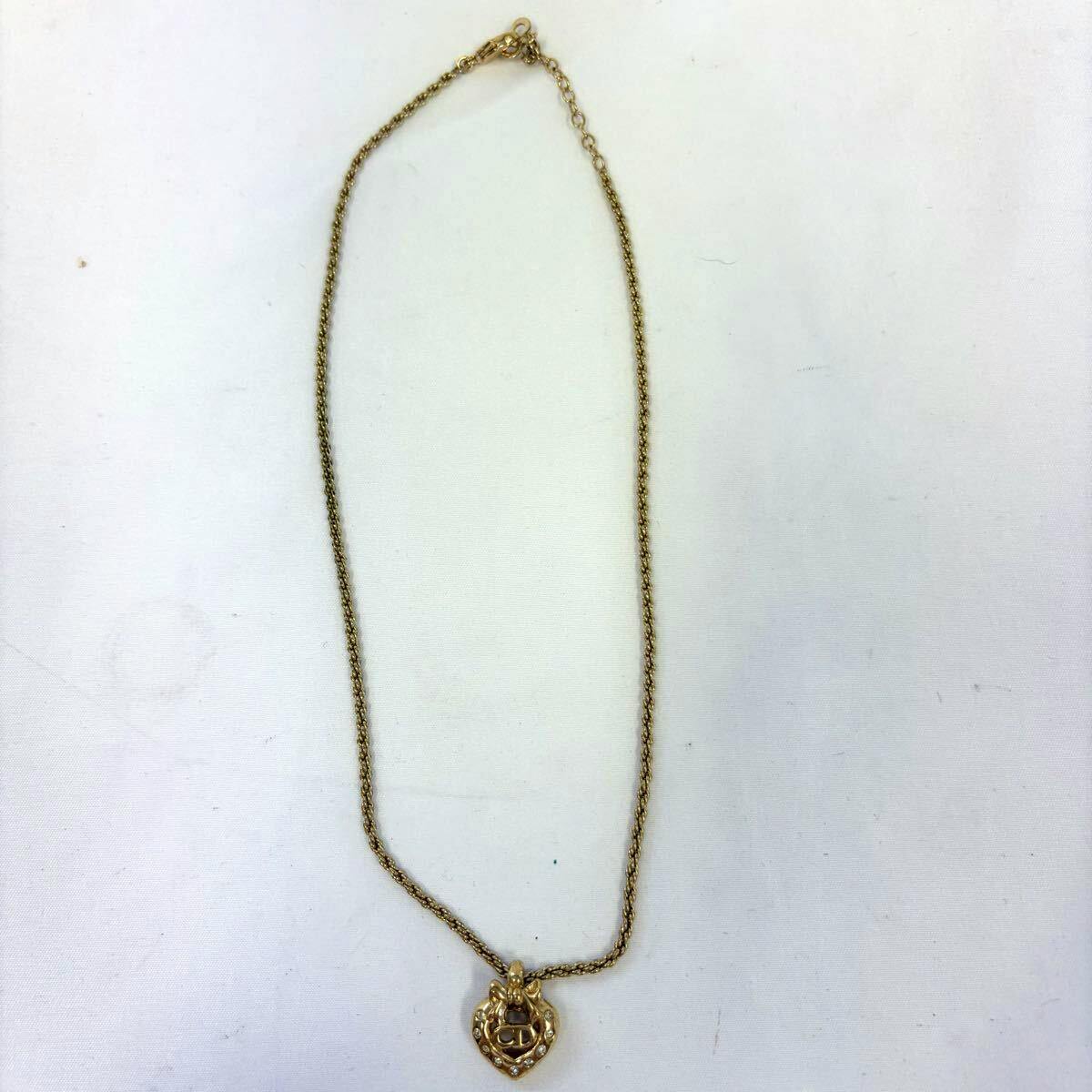 Full Christian Dior gold-tone chain necklace with a heart-shaped CD logo pendant adorned with rhinestones, laid flat on a white background.