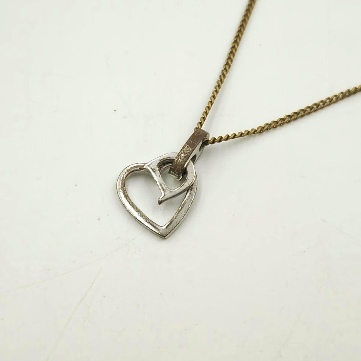 Christian Dior heart-shaped D logo necklace pendant on a chain displayed on a white background.