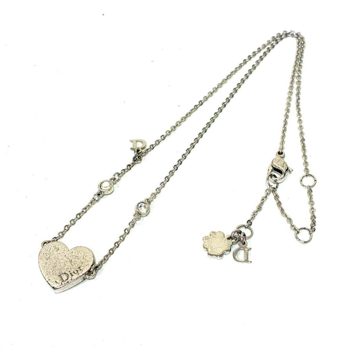 Silver-tone Christian Dior heart-motif necklace with small rhinestone accents laid flat on a white background.