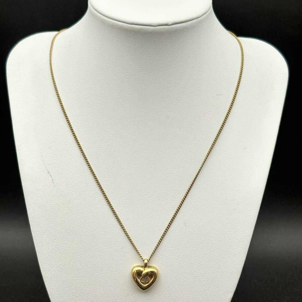 Gold-tone Christian Dior heart pendant necklace displayed on a white mannequin bust.