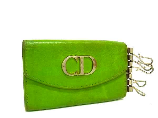 Light green Christian Dior leather 6-key case with CD logo on the front and metal key hooks extending from the side.