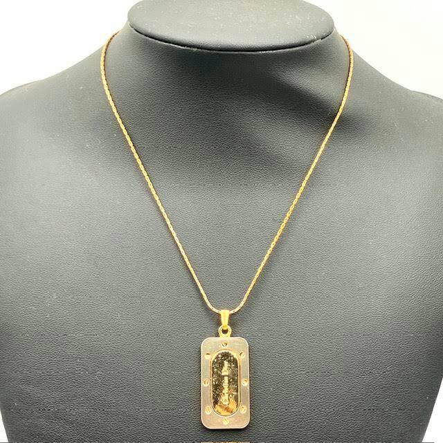 Christian Dior logo plate necklace displayed on a black jewelry bust.