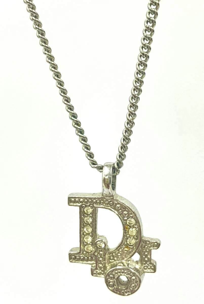 Silver-color Christian Dior necklace showing a 'D' Dior logo pendant with clear rhinestones on a silver chain.