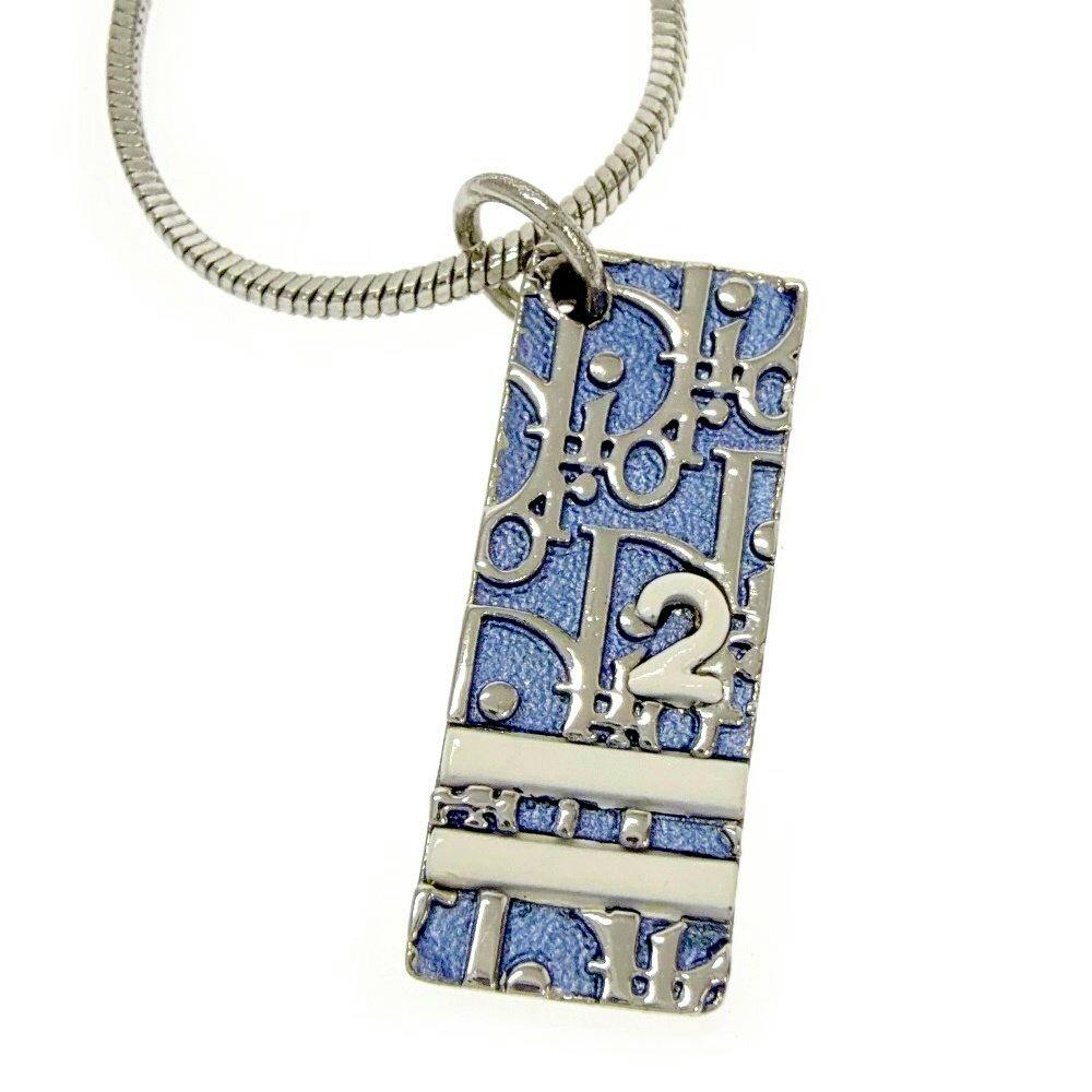 Close-up of the necklace's rectangular silver-tone metal pendant with blue enamel on a silver snake chain.