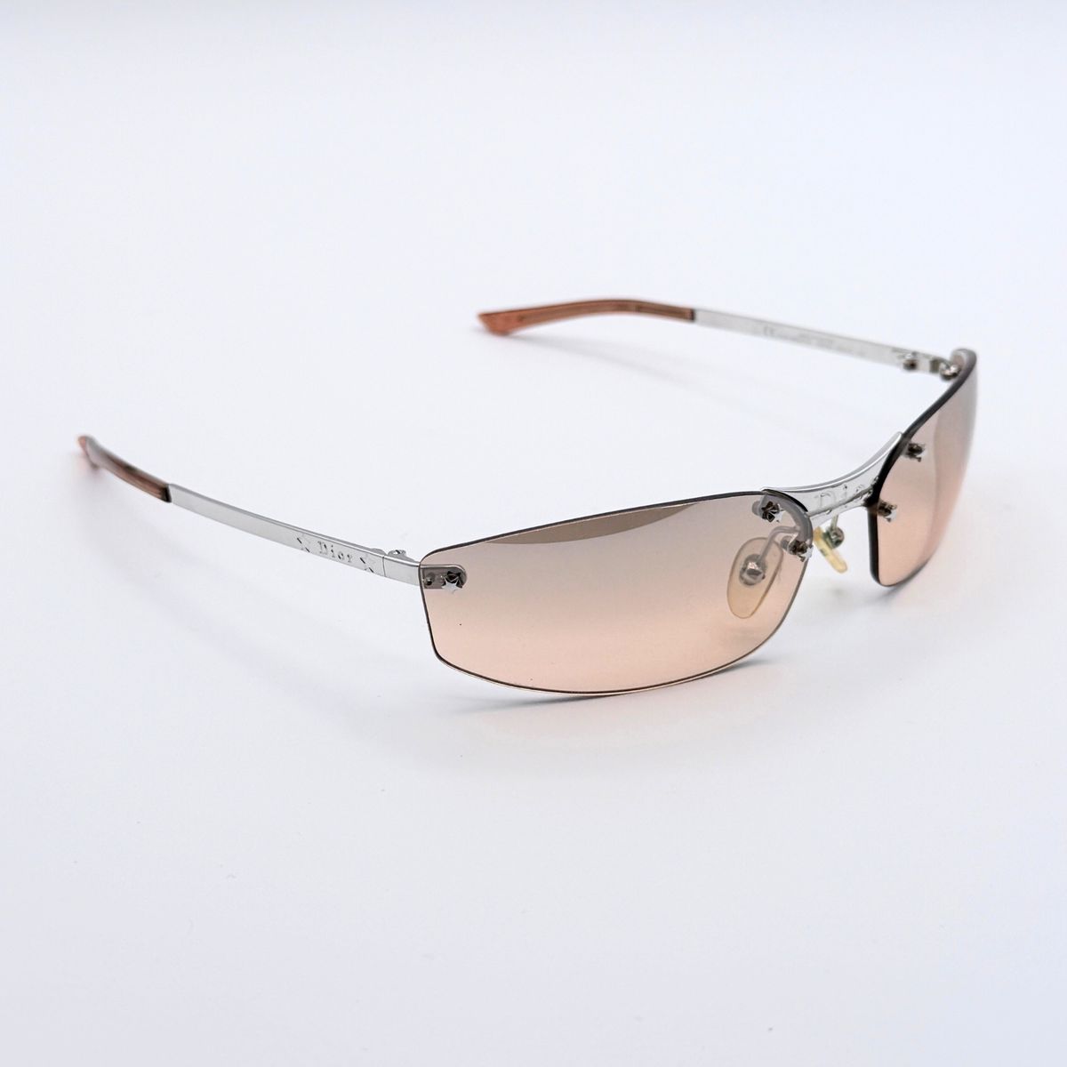 Brown oval Christian Dior MINIPOP women's sunglasses with metal temples displayed on a white background.