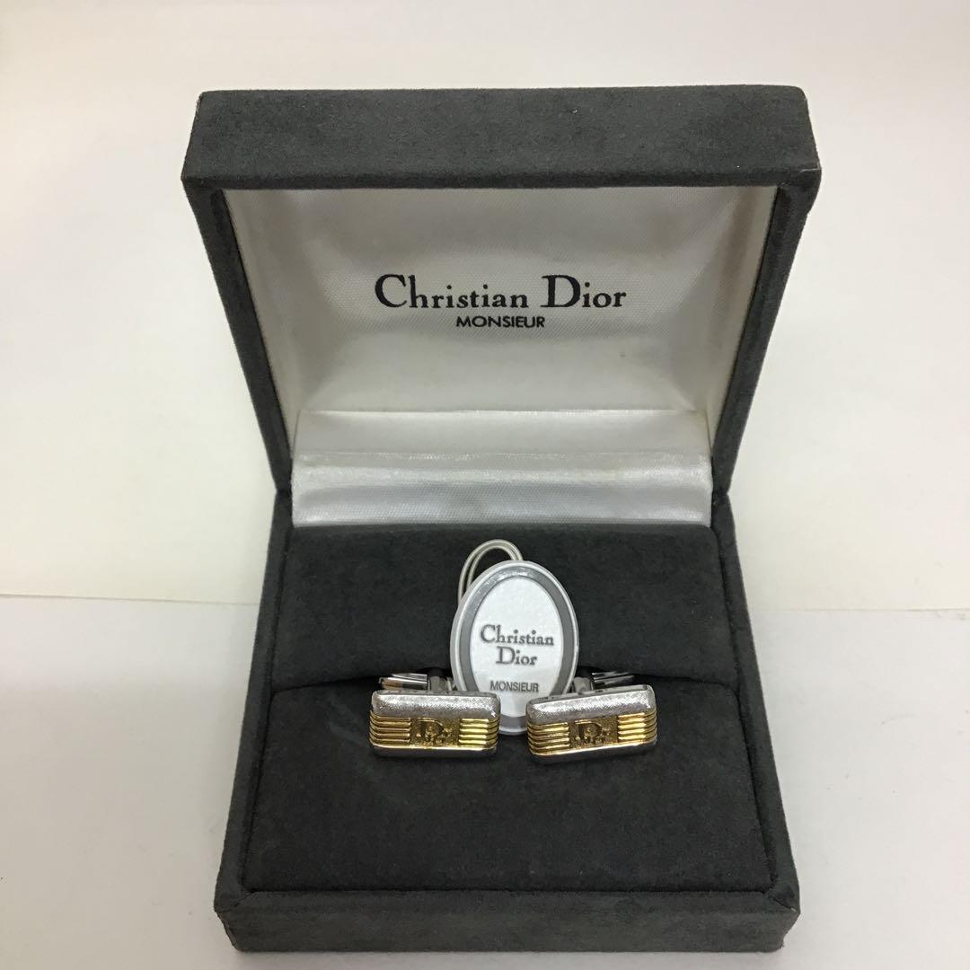 Pair of Christian Dior Monsieur cufflinks shown inside an open grey presentation box.