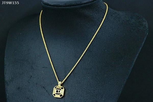 Gold-tone Christian Dior necklace with a geometric pendant displayed on a black necklace bust.