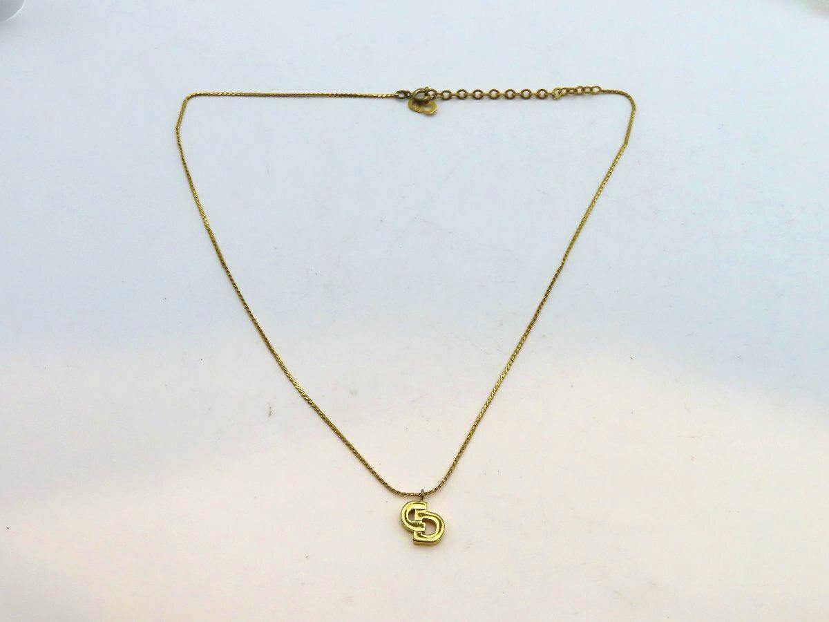Gold-colored Christian Dior necklace with a small interlocking "CD" pendant displayed on a white background.