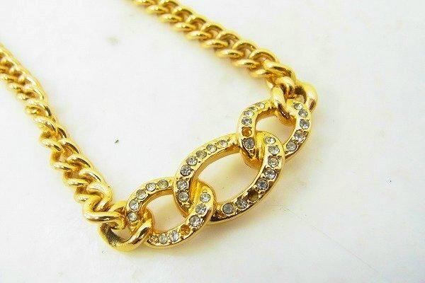 Close-up of a Christian Dior necklace showing a chain with three crystal-embellished interlocking links.