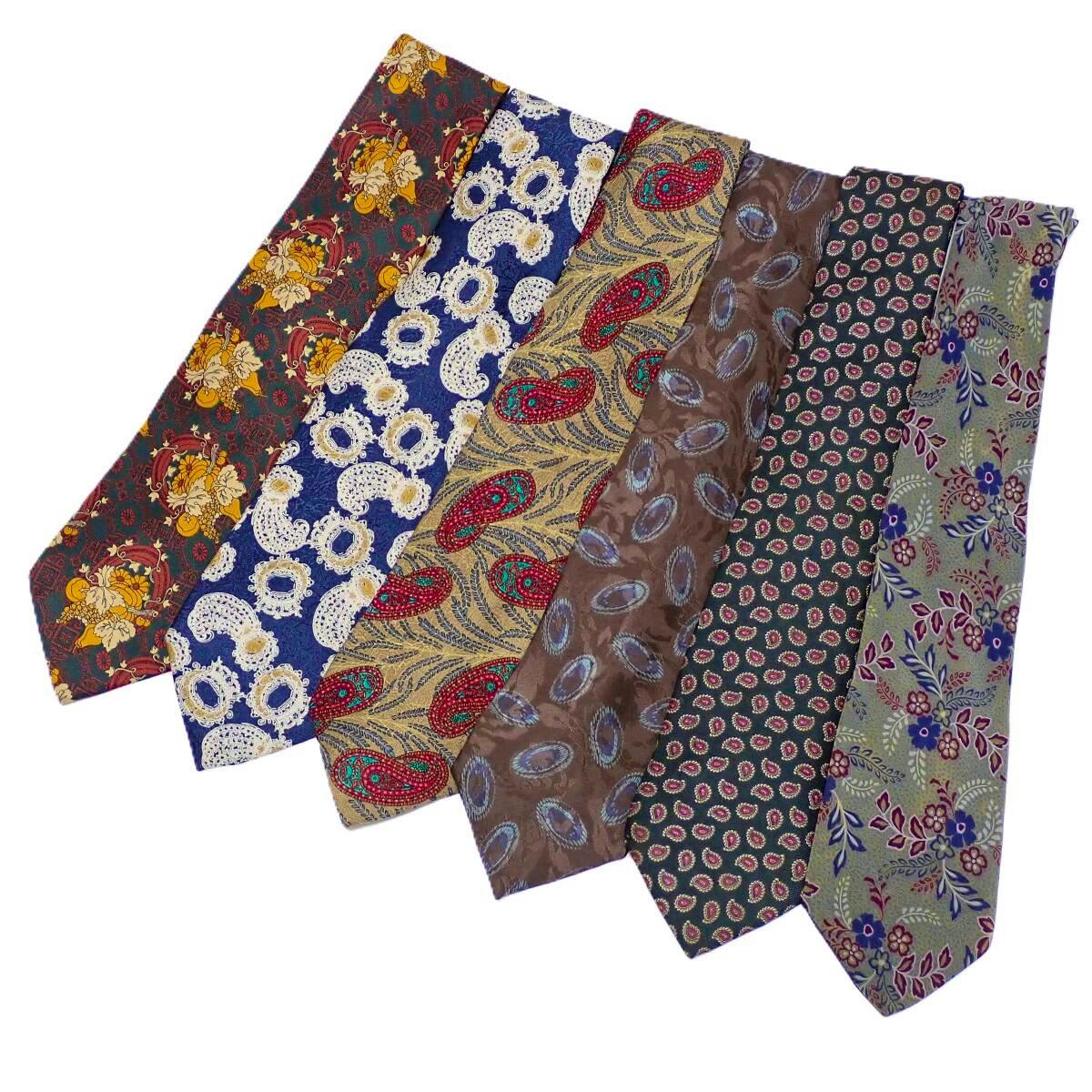 Six patterned Christian Dior neckties arranged side by side on a white background.