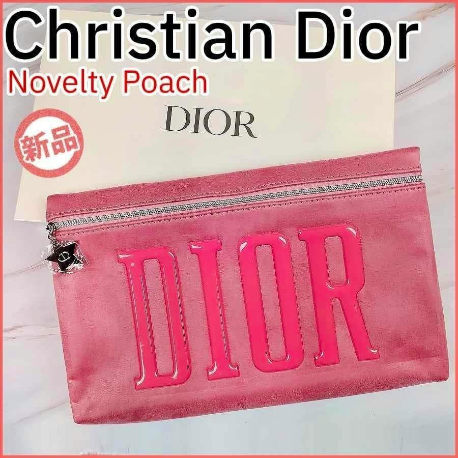 Pink Christian Dior pouch with large DIOR letters on the front placed in front of a Dior box.