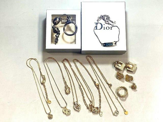 Several necklaces, rings, and earrings arranged with Dior boxes on a white background.