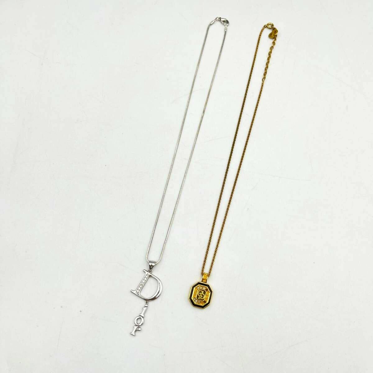 Two Christian Dior necklaces with pendants laid flat on a white background.