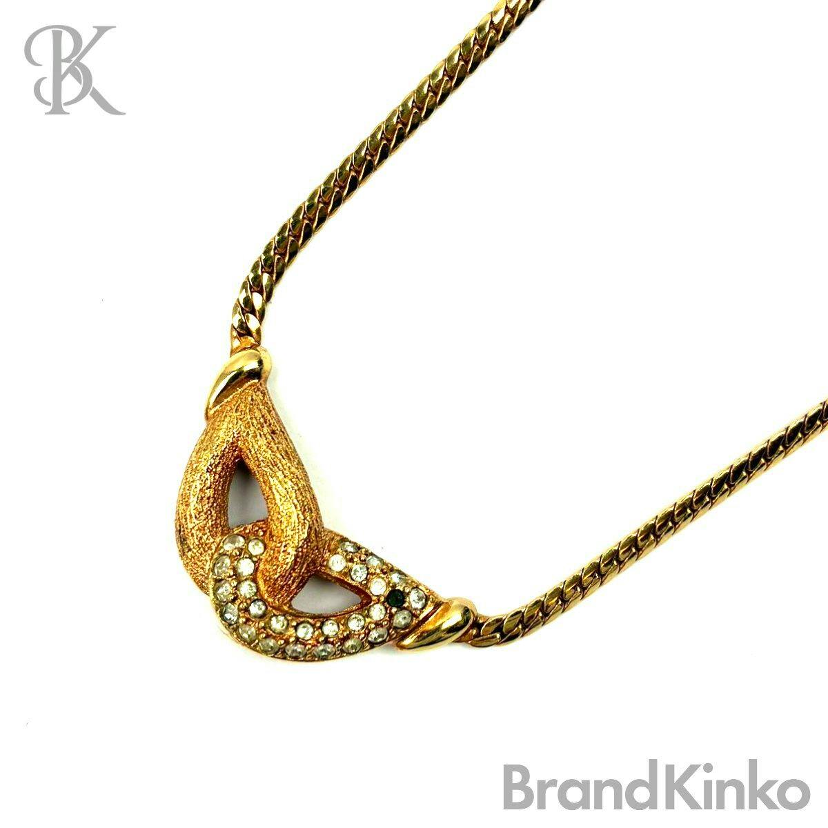 Close-up of a Christian Dior rhinestone-top snake chain necklace pendant and part of the gold-tone chain on a white background.