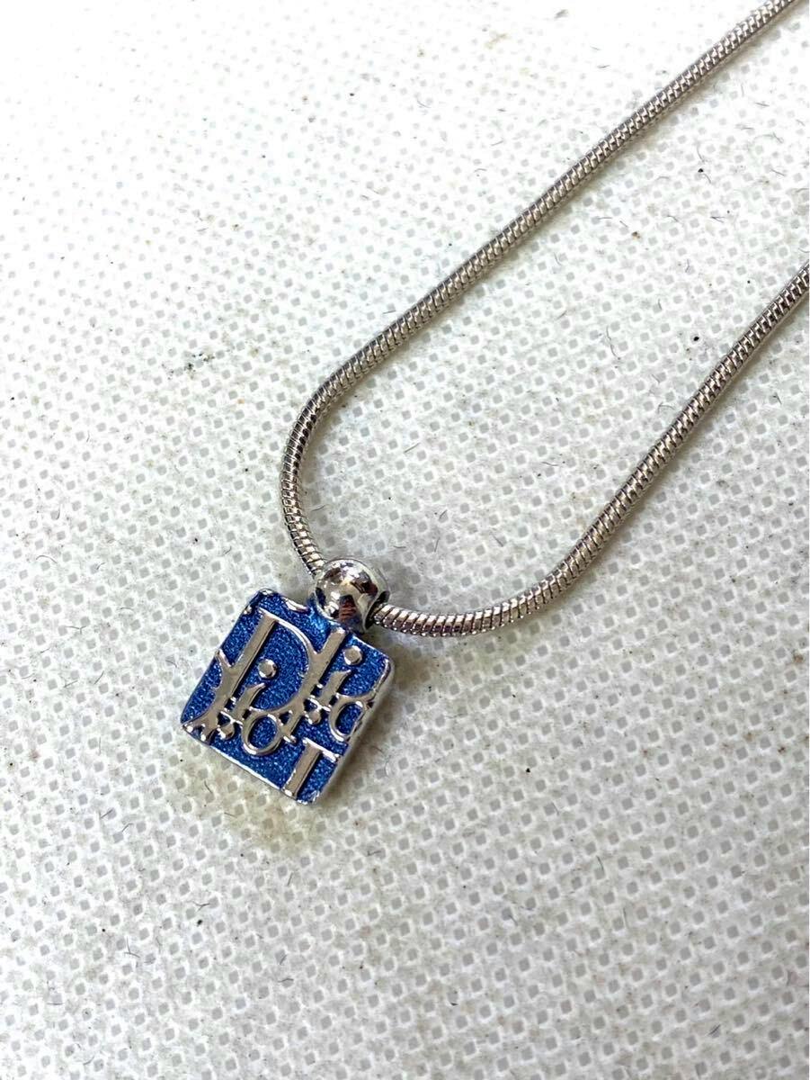 Silver-tone snake chain necklace with a small blue square Christian Dior pendant showing raised Dior lettering.