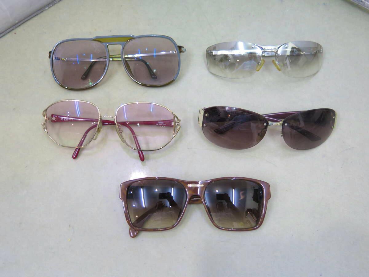 Five Christian Dior sunglasses arranged flat on a light-colored surface.