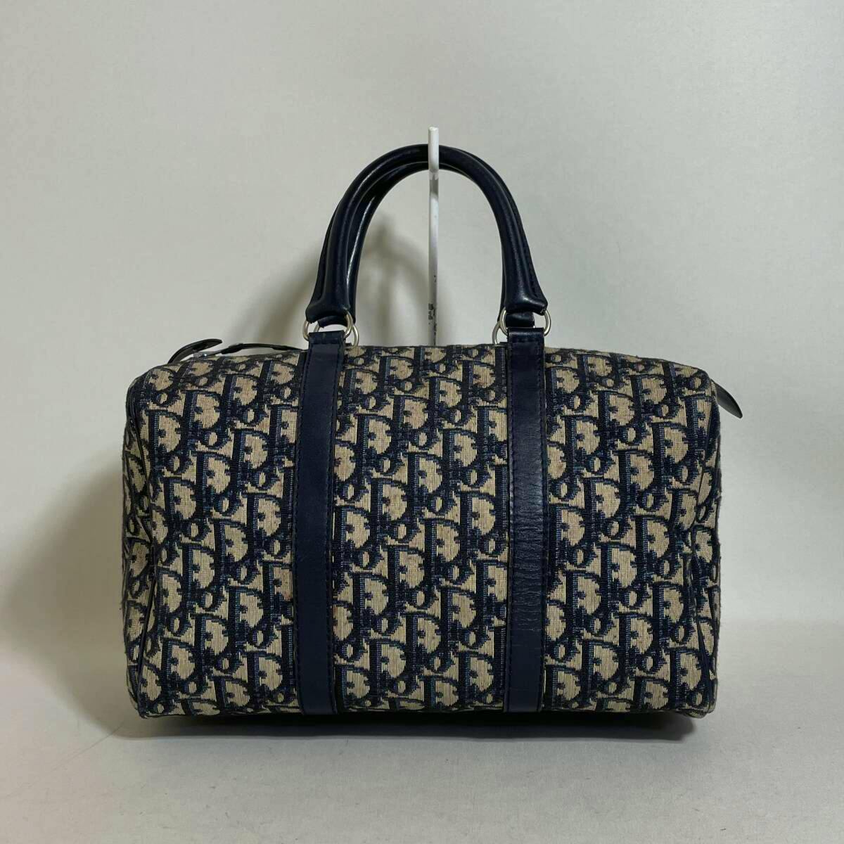 Front view of a navy Christian Dior Boston canvas bag with trotter pattern and double top handles on a plain background.